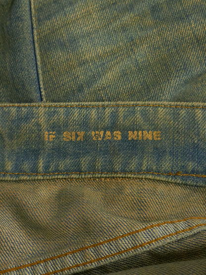 Close-up of denim fabric with 'If Six Was Nine' embroidery.