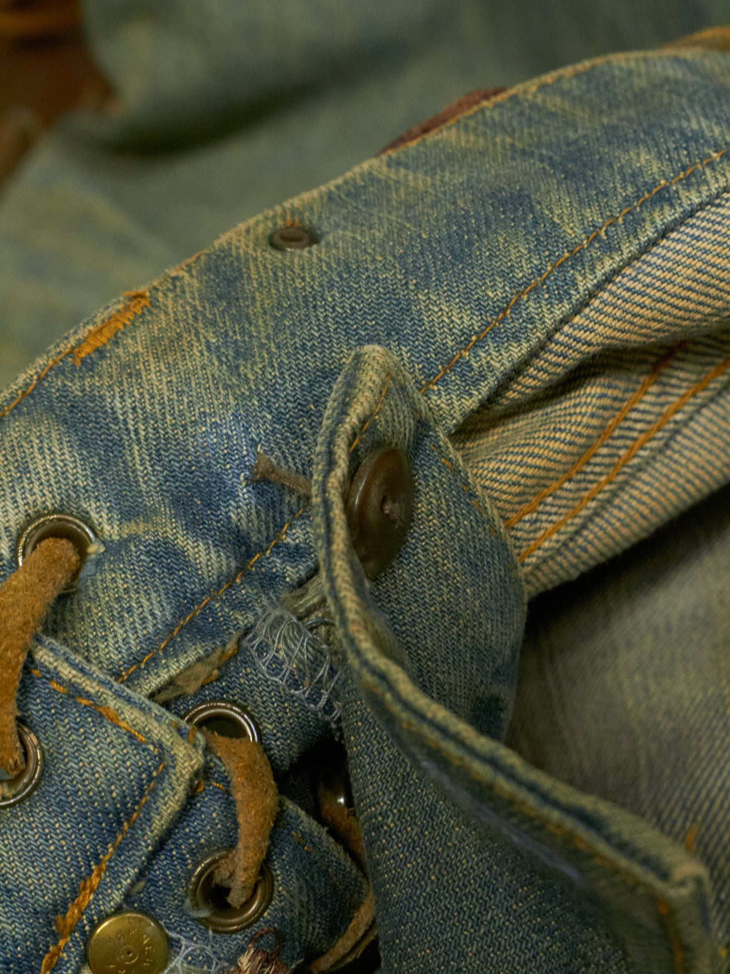 Close-up of blue denim fabric with buttons and stitching