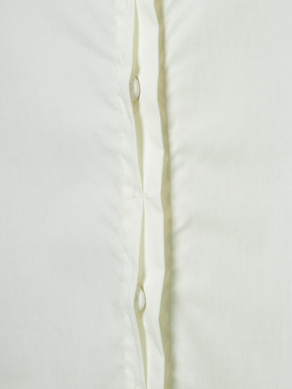 Close-up of a white button-up shirt showing the front placket with white buttons and a subtle vertical crease.