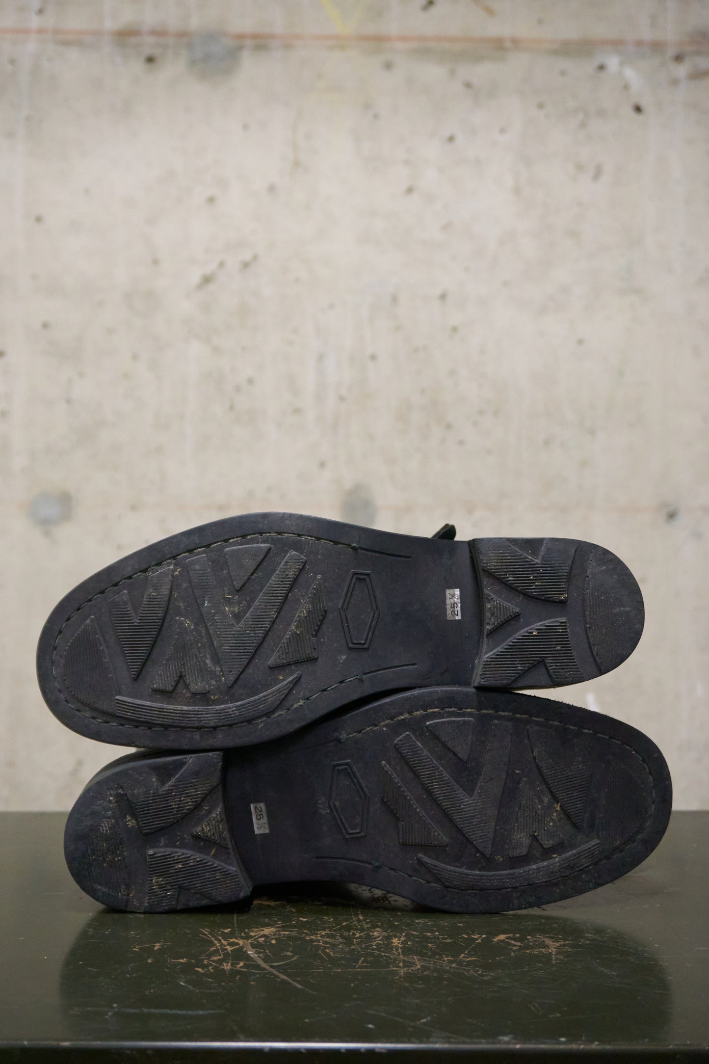 Black shoes with visible branding on a textured surface