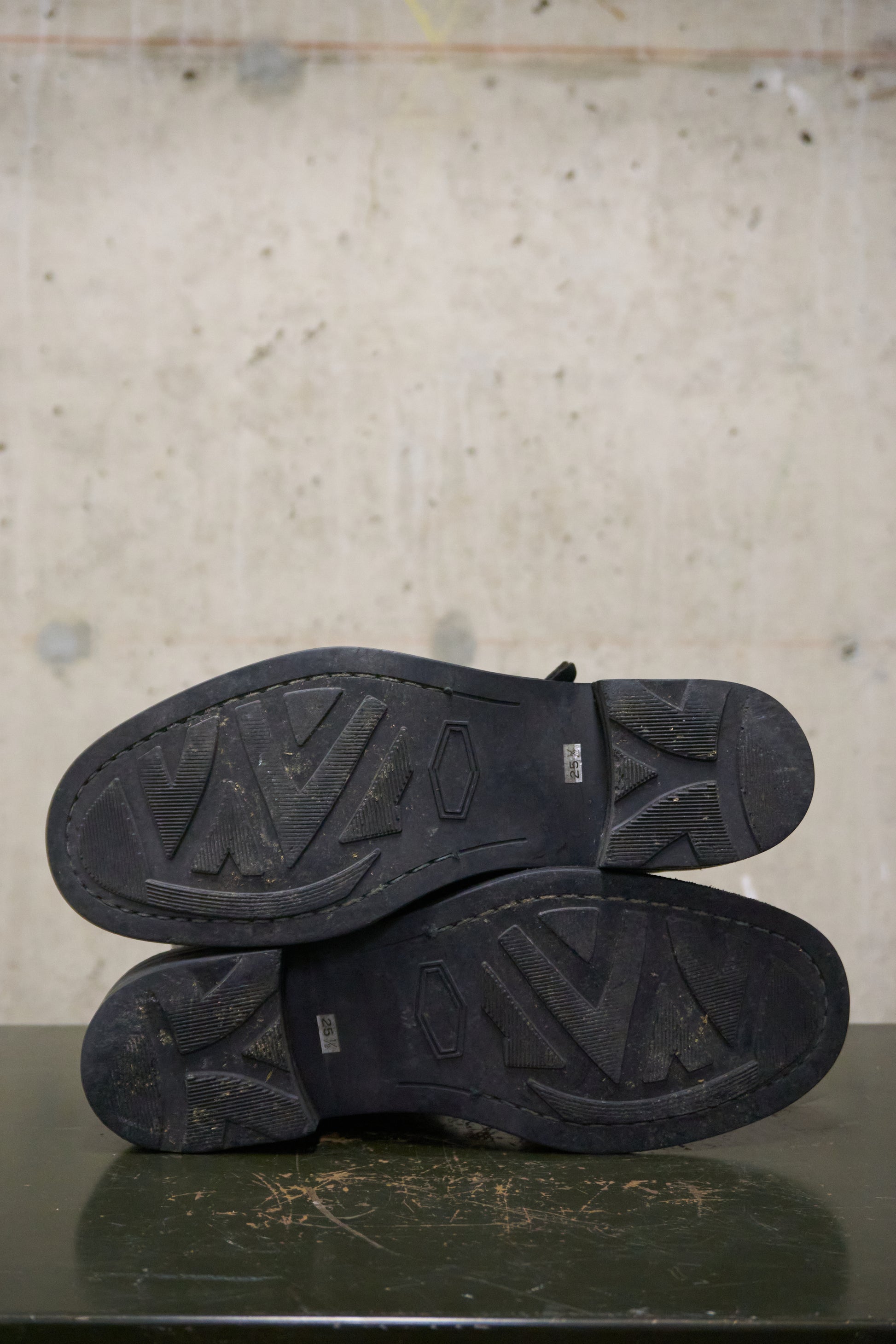 Black shoes with visible branding on a textured surface