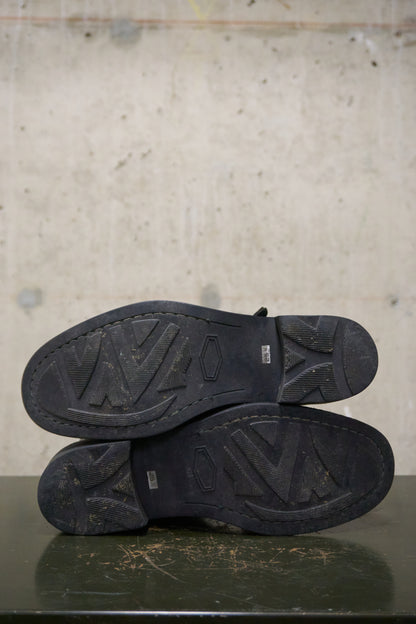 Black shoes with visible branding on a textured surface