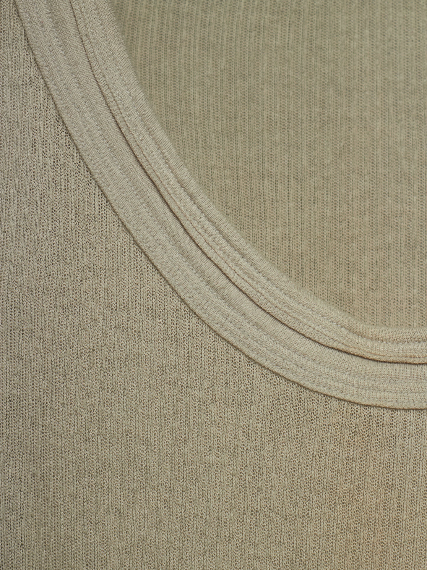 Close-up of a ribbed knit fabric with a wide, double-ribbed neckline in a light beige color.