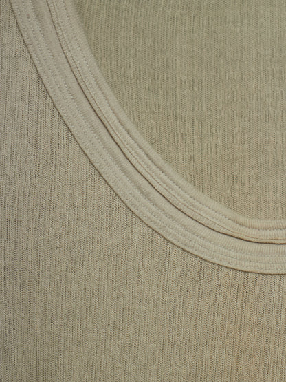 Close-up of a ribbed knit fabric with a wide, double-ribbed neckline in a light beige color.