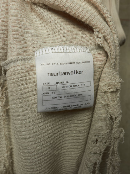 Close-up of a beige ribbed knit garment with a white sewn-in label reading 'neurbanvölker' and product details, showing frayed textured fabric around the collar area.