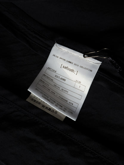 A close-up of a white product tag attached to a black garment with a metal clip, showing printed text including the brand name 'seifroth;'.