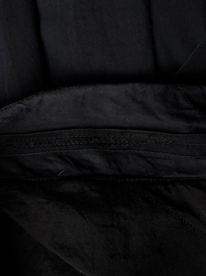 Close-up detail of a black fabric item showing a stitched seam and textured material.