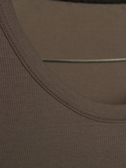 Close-up detail of a ribbed knit garment, showing the scoop neckline with double-stitched trim and a thin elastic band.