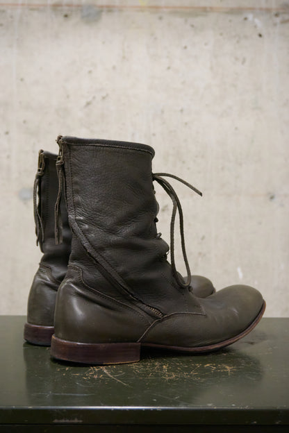 Pair of brown leather boots on a textured surface with a neutral background