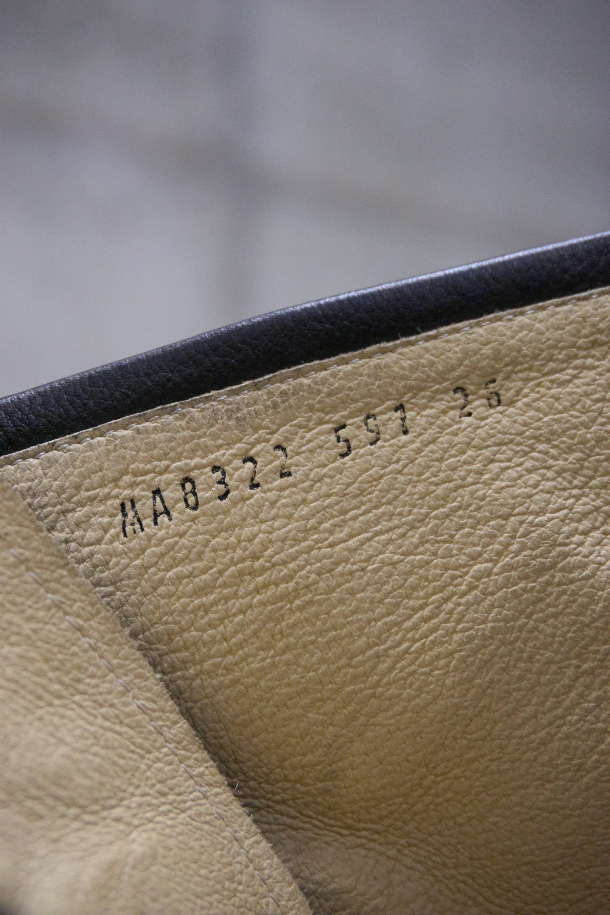 Close-up of beige leather with embossed text on a blurred background