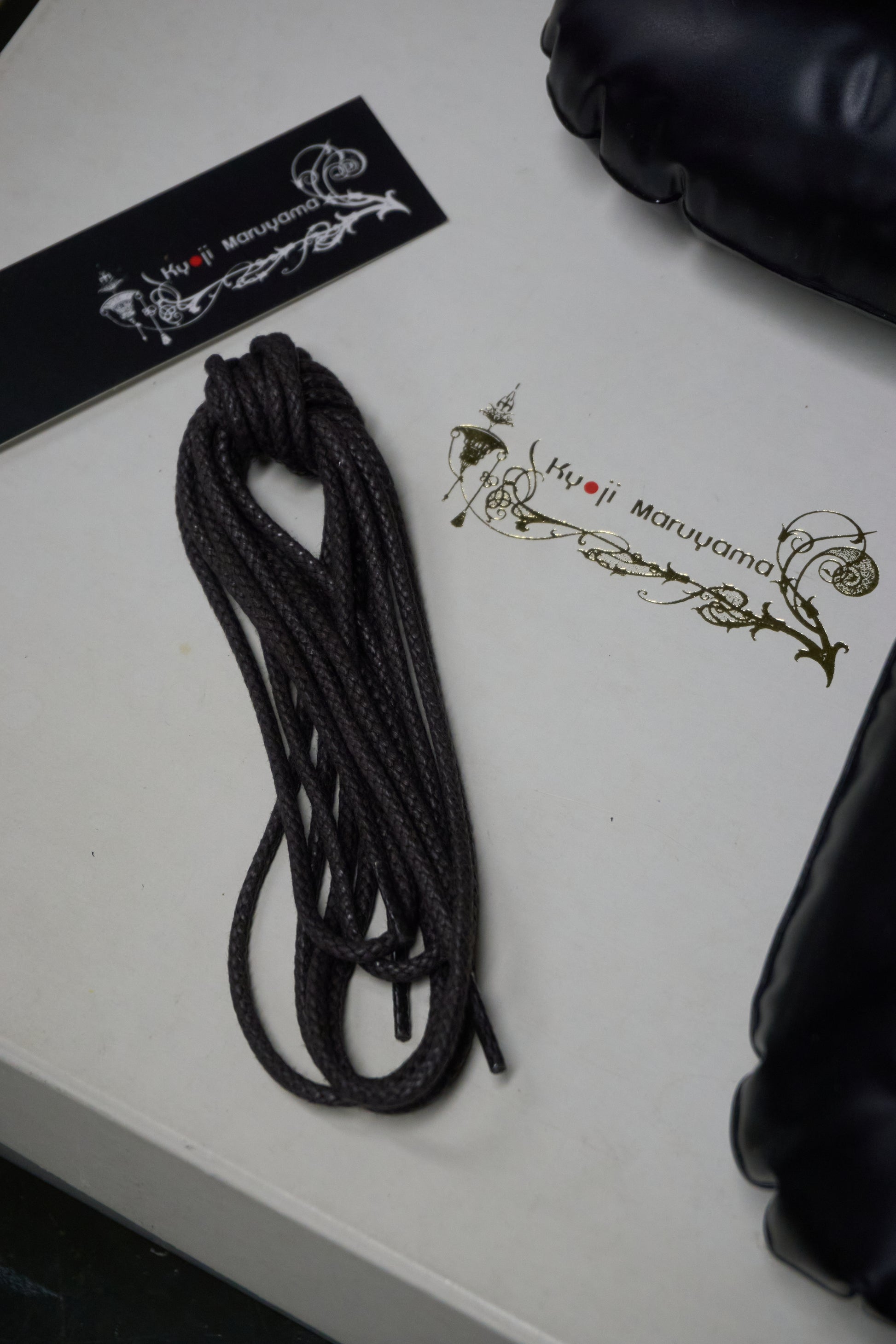 Black rope on a white surface with branding visible