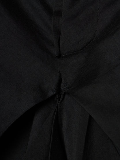 Close-up of a black fabric garment showing a gathered waist or pleated detail with visible stitching.