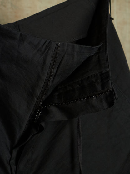 Close-up of a black lightweight jacket or windbreaker showing a zippered pocket and fabric texture.
