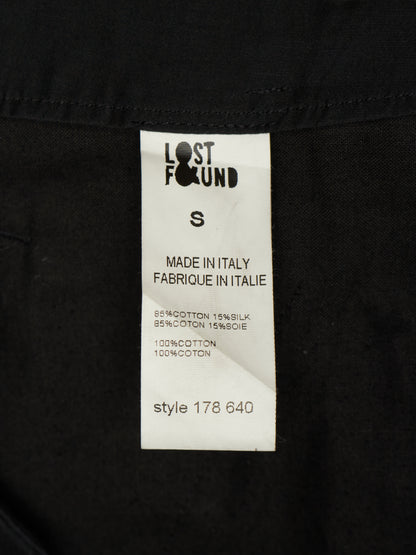 A close-up of a black garment's inner label, showing the Lost Found brand tag with size S and 'Made in Italy' text.