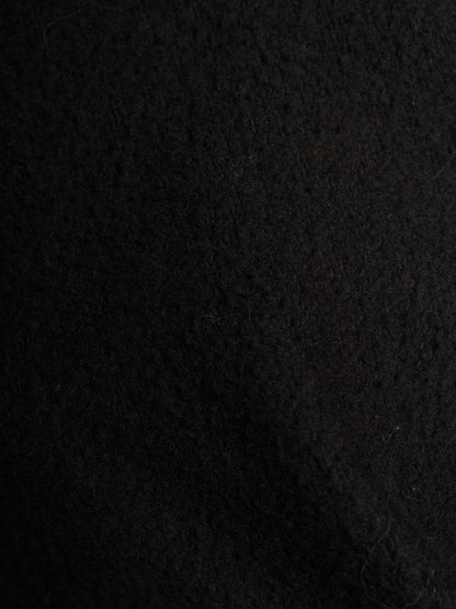 A close-up texture shot of a black felt or wool-like fabric surface.