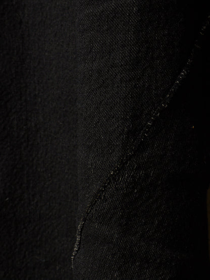 Close-up of black textured fabric with a diagonal seam running through the center.