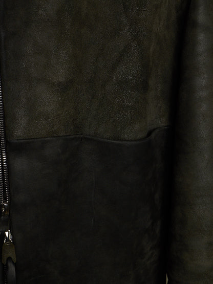Close-up of a dark brown leather jacket showing a textured suede-like upper panel, smooth leather lower panel, and a black zipper on the left side.
