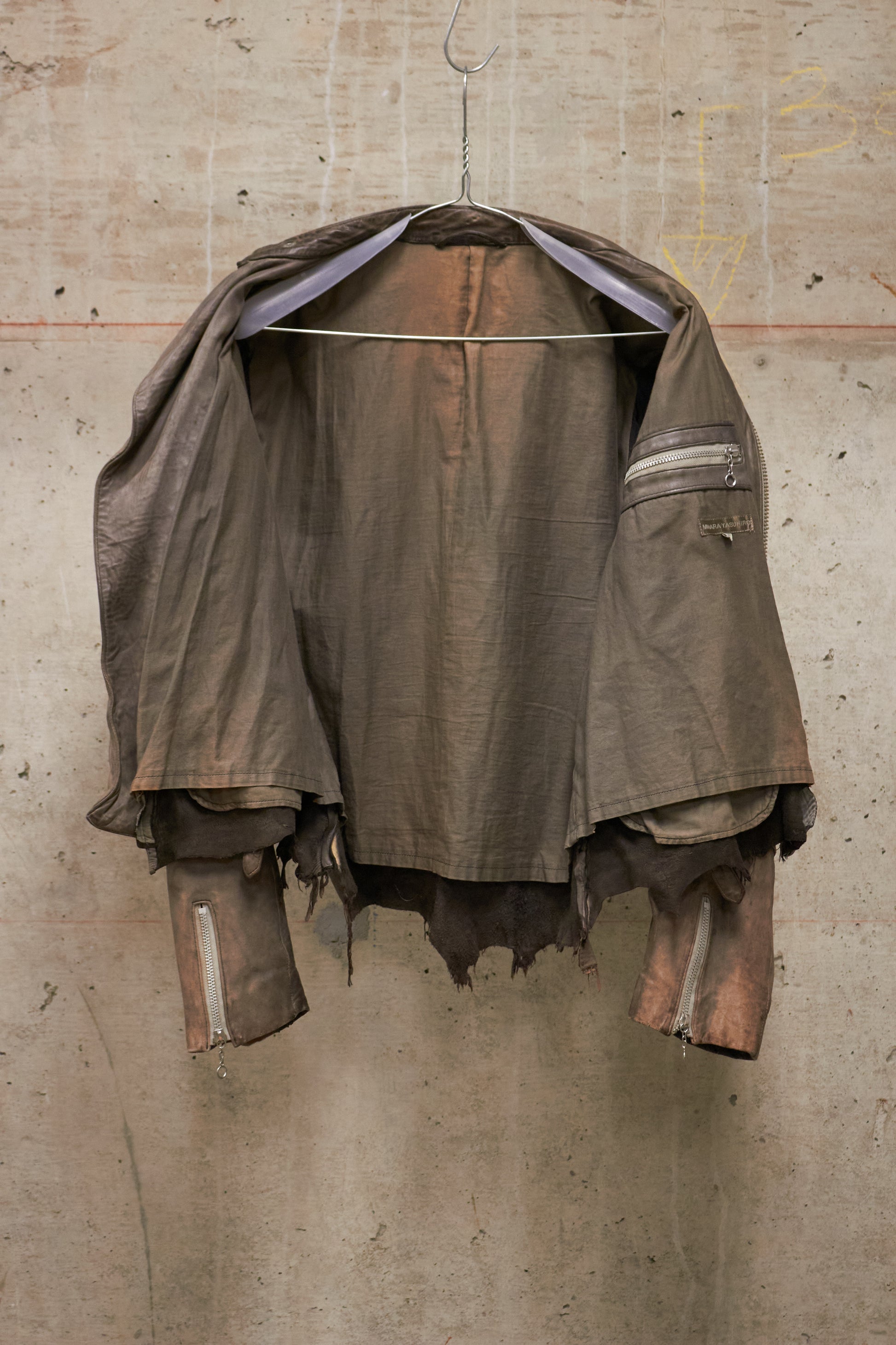 Rustic brown jacket hanging on a concrete wall