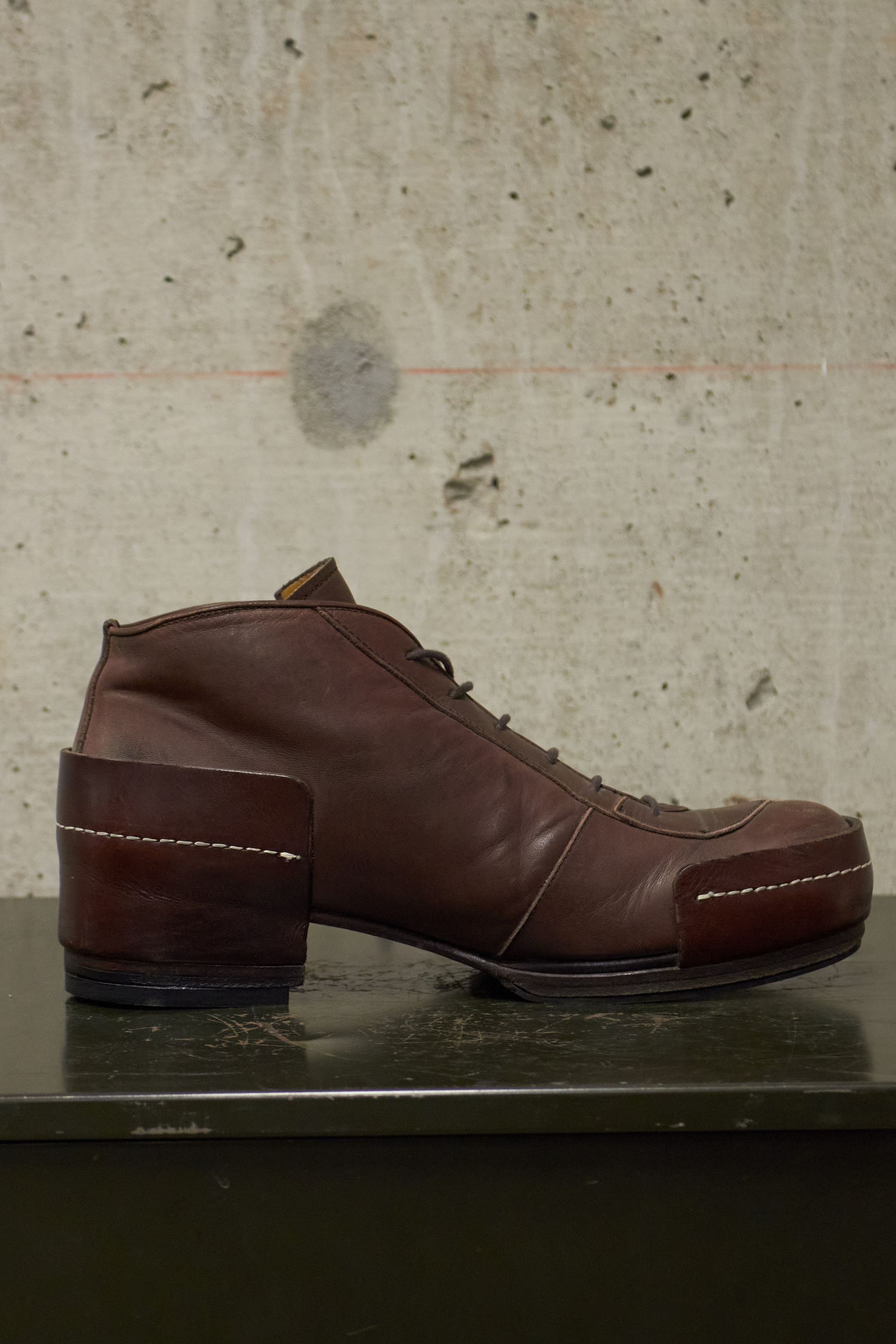 Brown leather shoe on a concrete surface