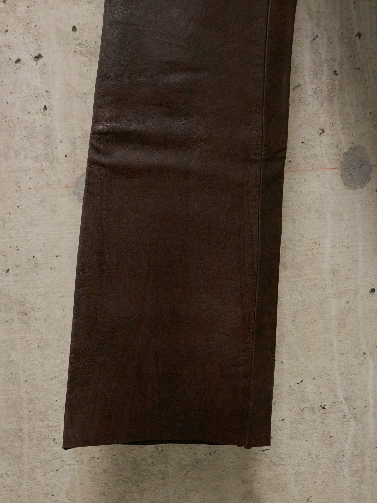 Brown leather jacket on a textured beige surface