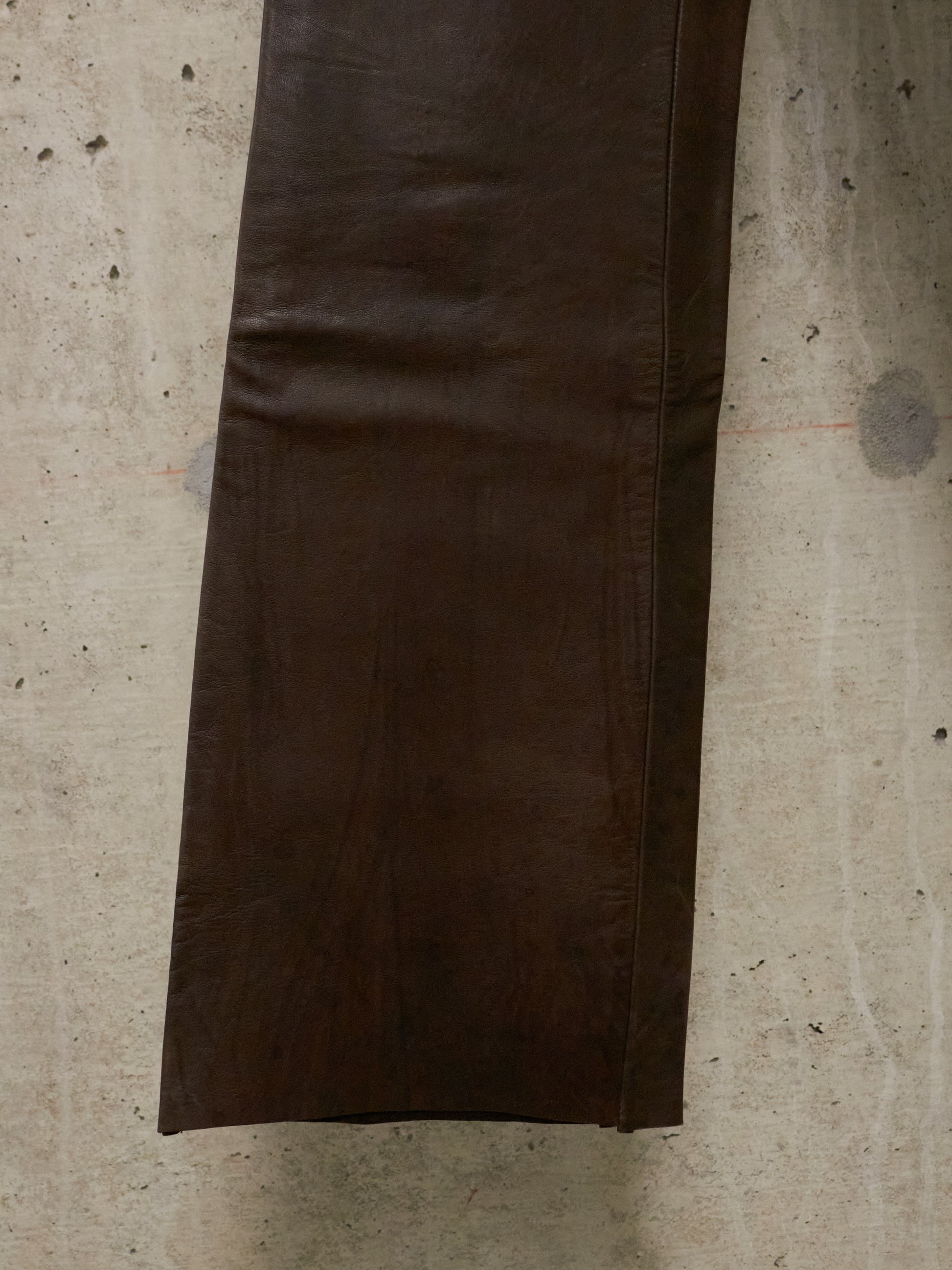 Brown leather jacket on a textured beige surface