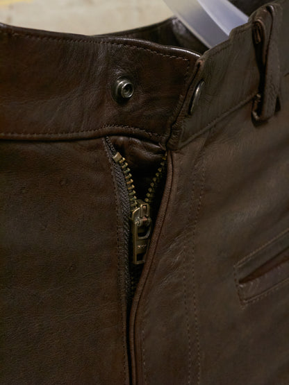 Close-up of a brown leather jacket with a zipper