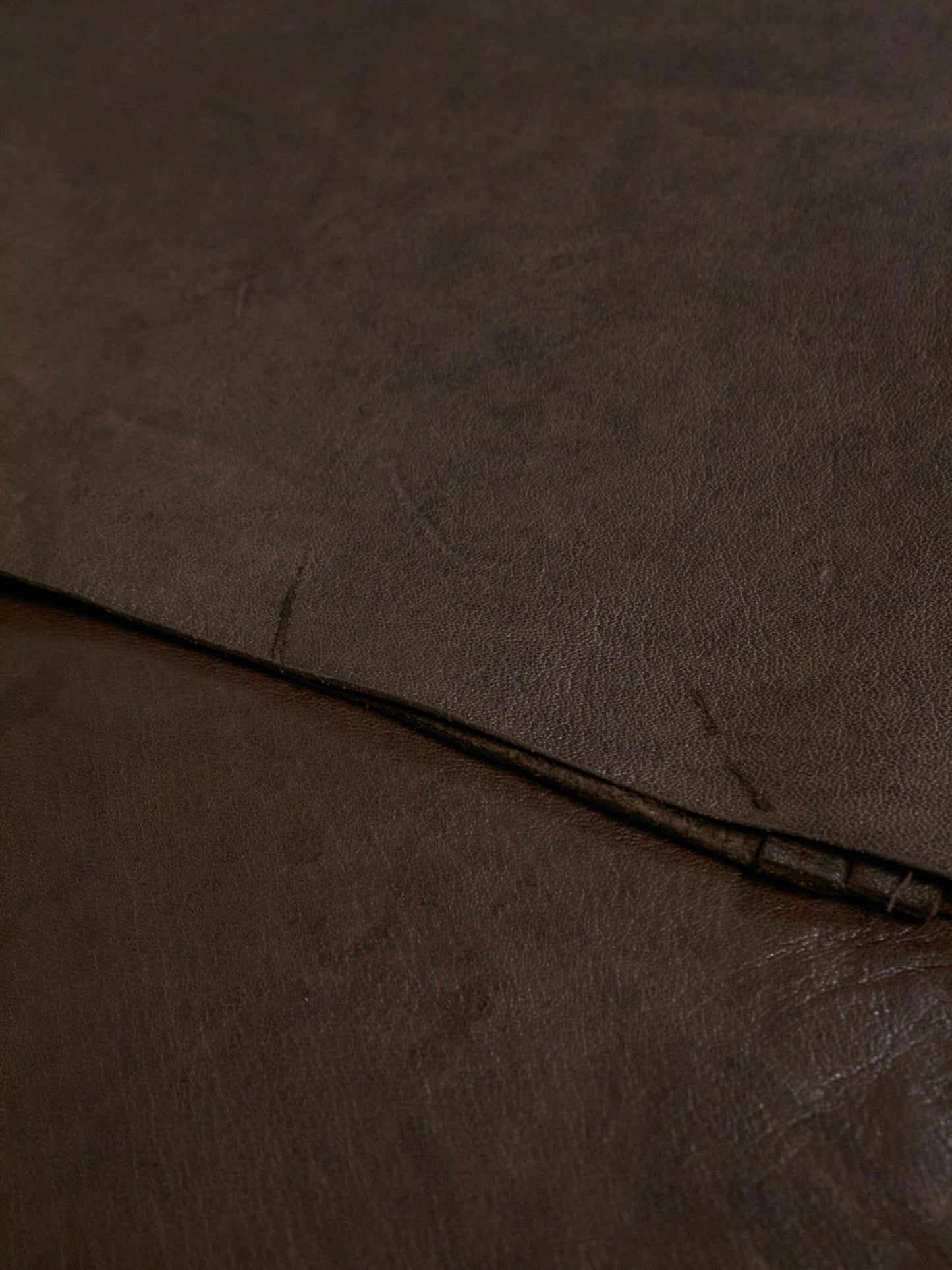 Close-up of brown leather surface with visible stitching