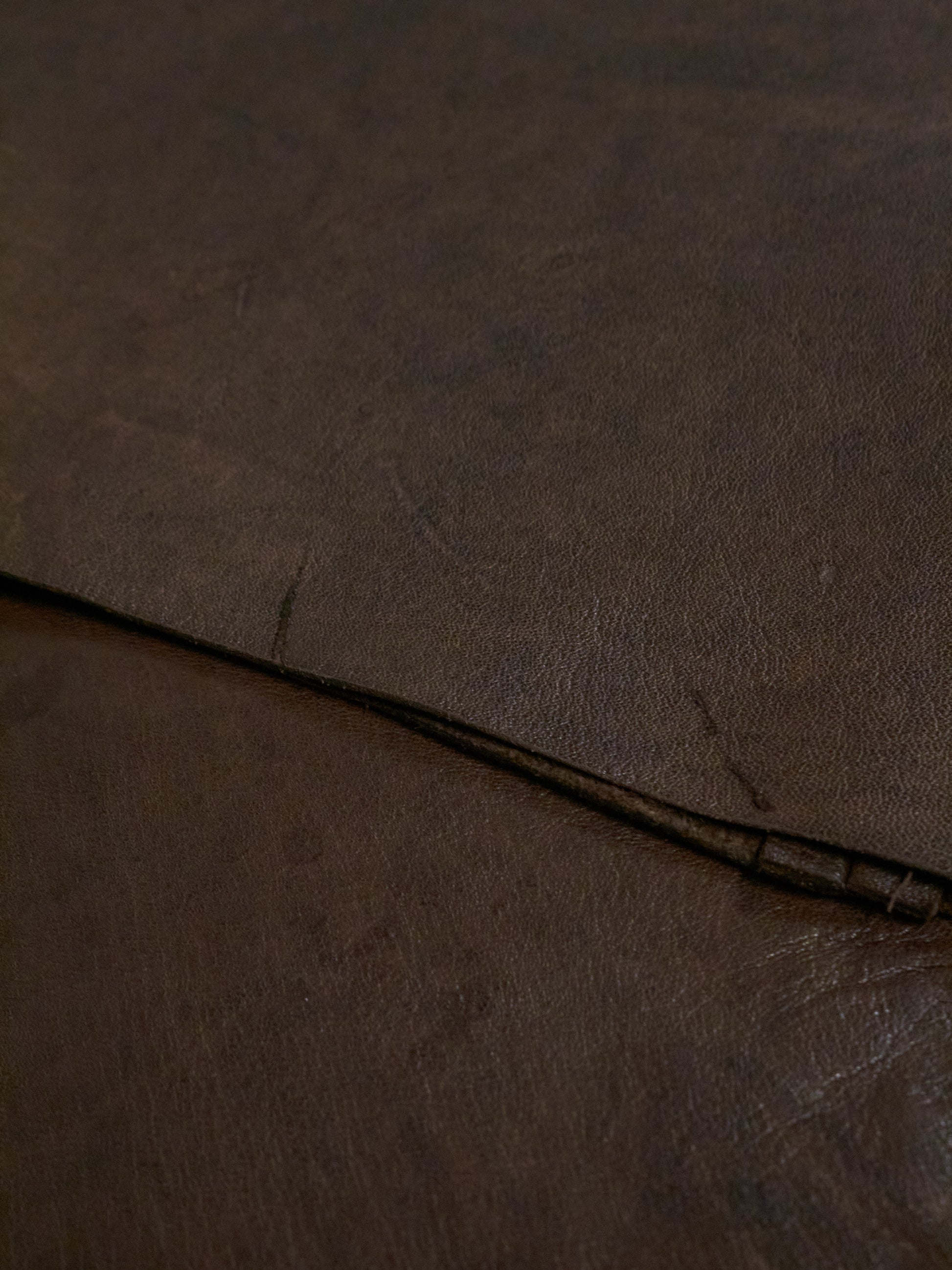 Close-up of brown leather surface with visible stitching
