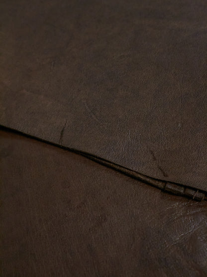 Close-up of brown leather surface with visible stitching