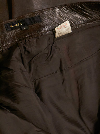 Close-up of dark brown pants with a brand label on the waistband.