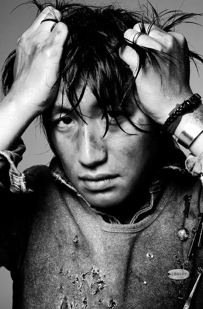 Mihara Yasuhiro portrait in black and white holding hair up — experimental avant-garde Japanese clothing designer