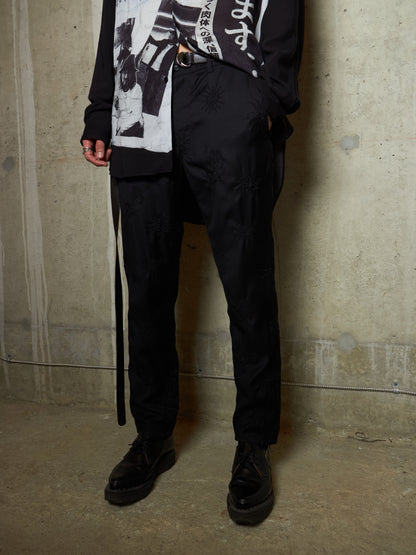 Person wearing a black outfit with a textured wall background