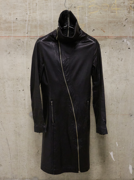 Black raincoat on a hanger against a textured wall.