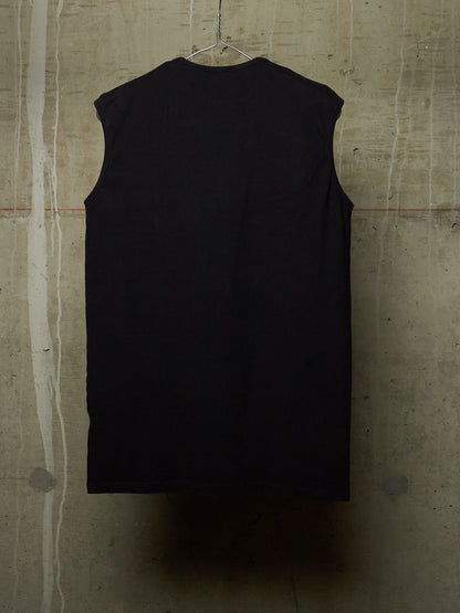 A black sleeveless top hanging on a wire hanger against a textured concrete wall.