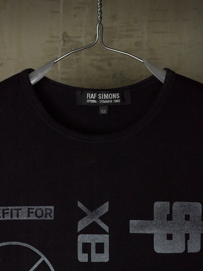 A black Raf Simons t-shirt hanging on a metal hanger against a textured concrete wall. The shirt features a gray graphic print on the front and a visible Raf Simons brand label inside the collar.