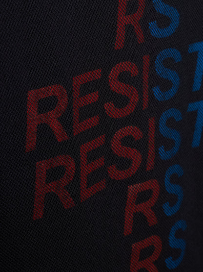 Close-up of a black textured fabric with large repeating 'RESIST' lettering in red and blue.