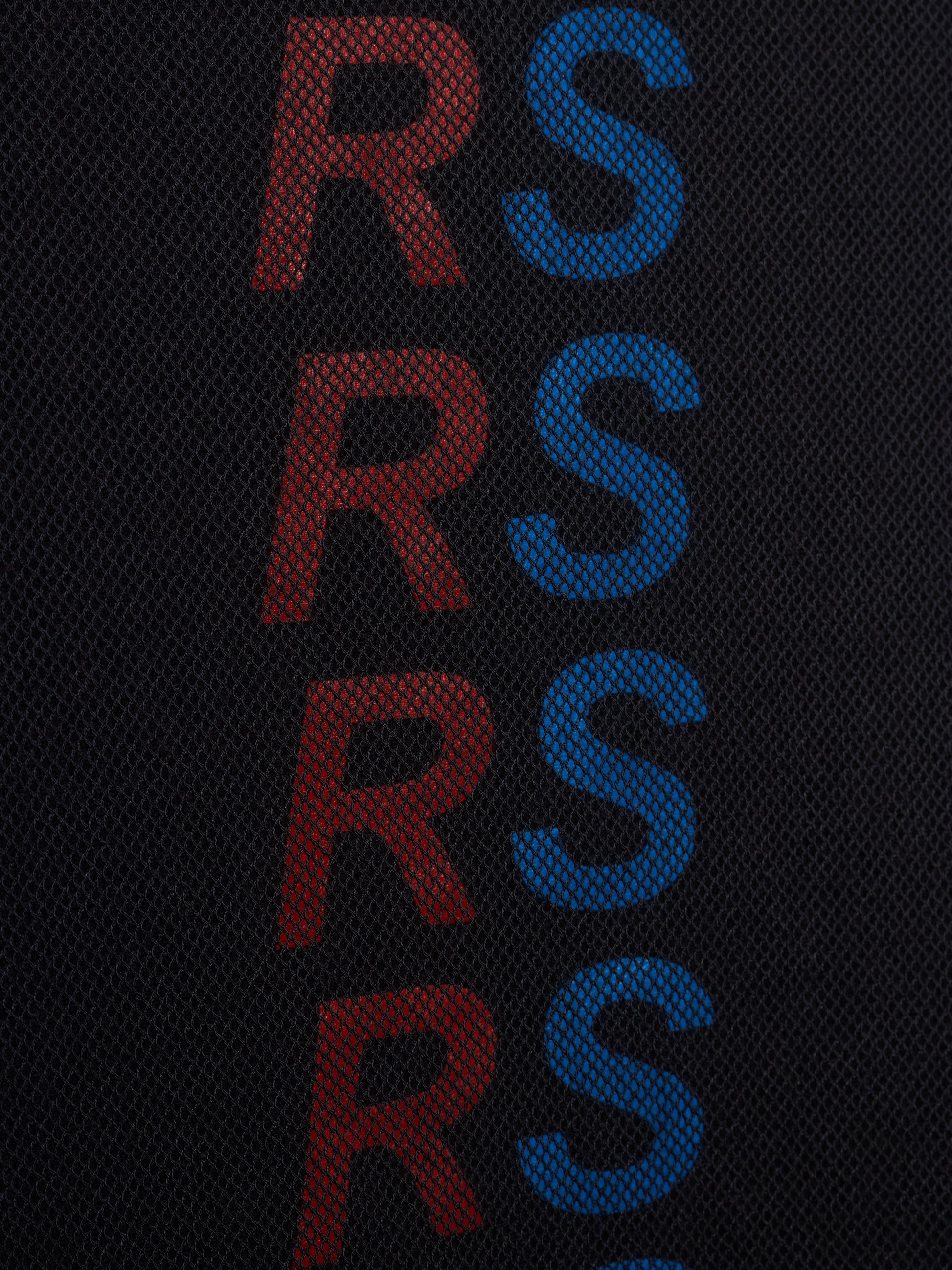 Close-up of a black mesh fabric with a vertical repeating pattern of the letters 'RS' in alternating red and blue.