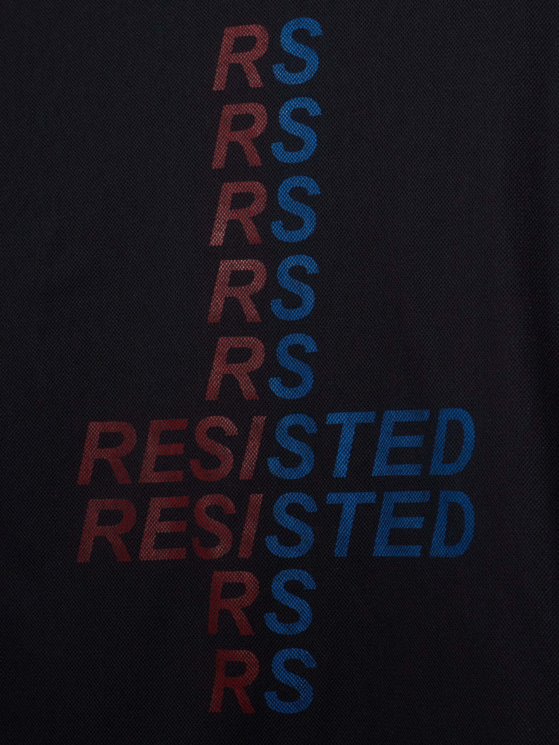 Close-up of a black textured fabric with a vertical graphic spelling 'RESISTED' in alternating red and blue letters.