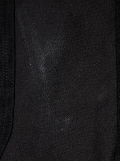 Close-up of a black fabric surface with a subtle sheen and a dark ribbed trim along the left and right edges.