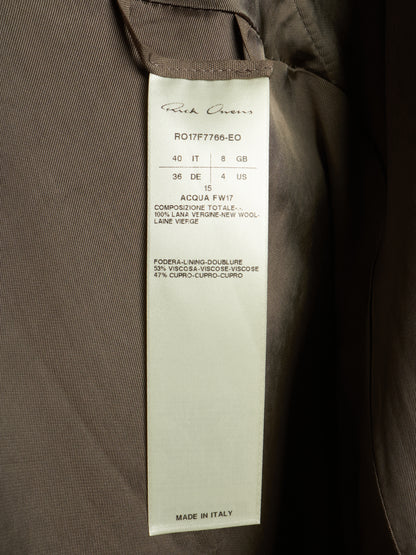 A close-up of a garment's interior label reading 'Rich Queen's' with product code 'R017F7765-EO' and 'MADE IN ITALY', attached to a dark brown fabric garment.