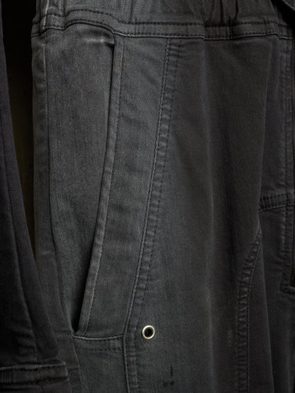 Close-up of dark charcoal gray canvas fabric with a side pocket and metal grommet detail.