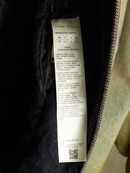 A close-up of a garment's interior zipper opening showing a white fabric care label with printed text, including the brand name 'Faithfull' and product details.