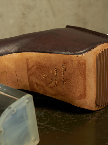 Close-up of the sole of a dark brown leather boot, showing the tan Vero Cloro rubber outsole and embossed branding, resting on a dark surface.