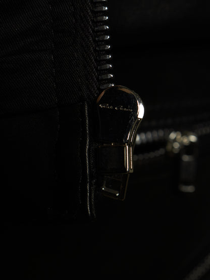 Close-up of a black zipper with a polished metallic pull tab engraved with the brand name 'Ghili & Ghili'.
