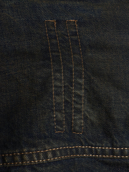 Close-up of dark indigo denim fabric with two vertical stitched channels and contrast tan stitching.