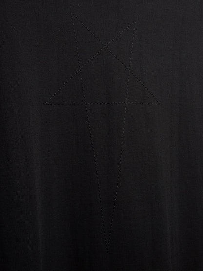 Close-up of a black ribbed knit fabric with a tonal embroidered or stitched star-like geometric motif in the center.