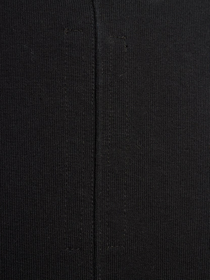 Close-up of a black textured knit fabric with a central seam running vertically.