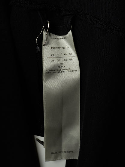 Close-up of a black garment's interior label showing the brand TOMSAM and size information for black cotton fabric.