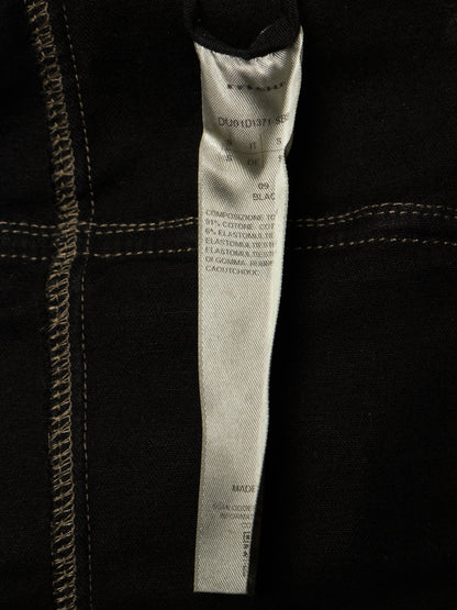 Close-up of a black garment's interior label, showing text including 'DUNLOP' and '409 BLACK'.