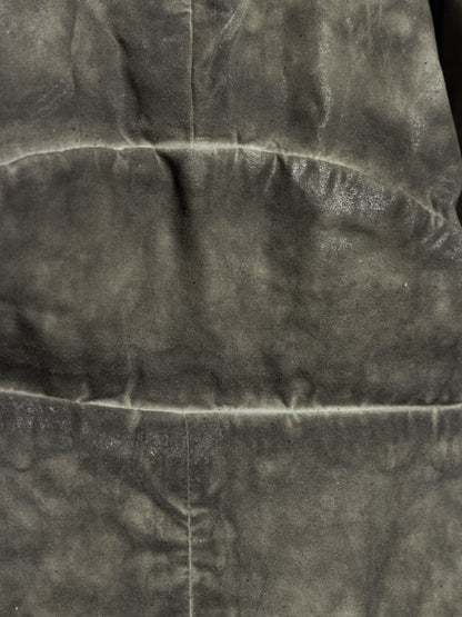 A close-up of a dark gray textured fabric with visible folds and a horizontal seam.